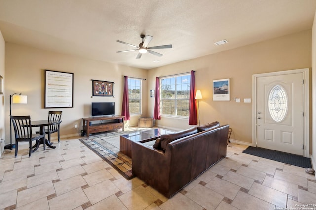 living room with a textured ceiling and ceiling fan