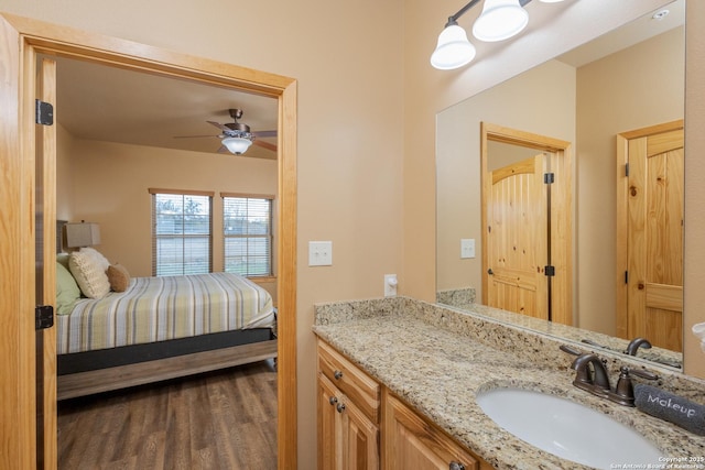 bathroom with hardwood / wood-style flooring, ceiling fan, and vanity