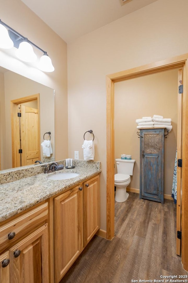 bathroom with vanity, hardwood / wood-style flooring, and toilet