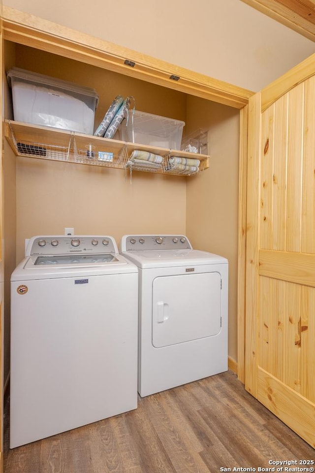 laundry room with hardwood / wood-style flooring and washing machine and dryer