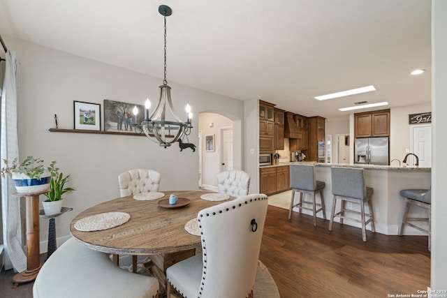 dining area with an inviting chandelier and dark hardwood / wood-style flooring