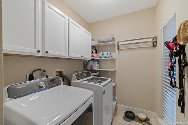 laundry area featuring independent washer and dryer, cabinets, and light hardwood / wood-style flooring