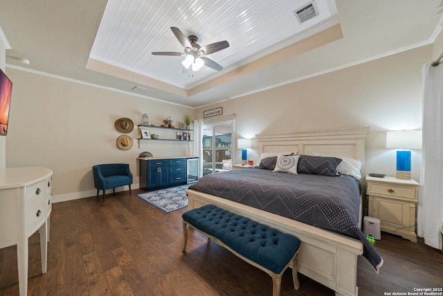 bedroom with a tray ceiling, dark wood-type flooring, ornamental molding, and ceiling fan