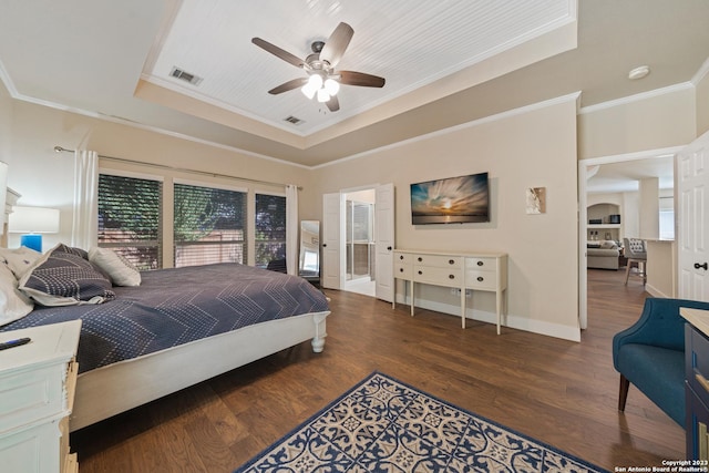 bedroom with dark wood-type flooring, ornamental molding, a tray ceiling, and multiple windows