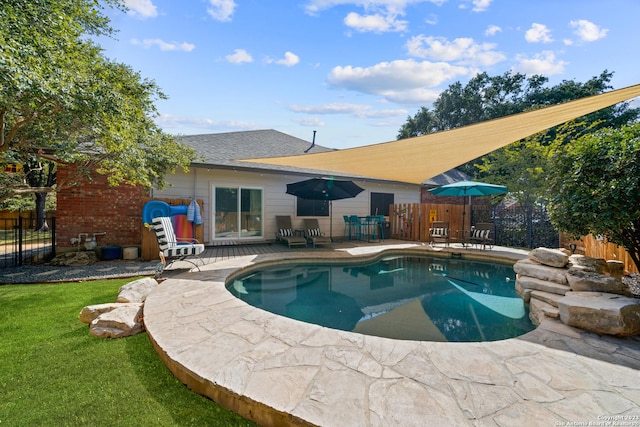 view of pool with a patio and a lawn