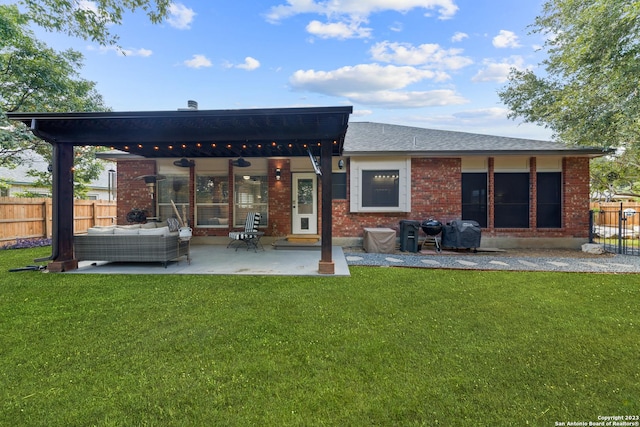 rear view of property with a yard, outdoor lounge area, and a patio