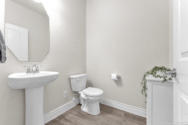 bathroom with hardwood / wood-style floors, sink, and toilet