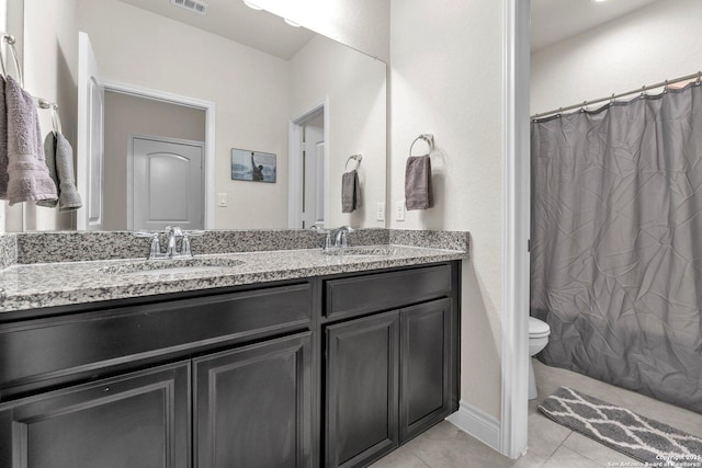 bathroom featuring vanity, tile patterned floors, and toilet