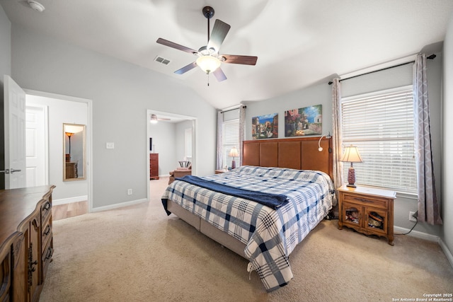 carpeted bedroom featuring vaulted ceiling, ceiling fan, and ensuite bath