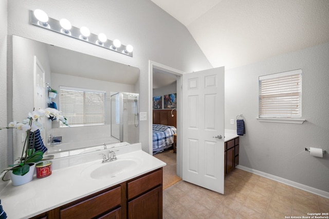 bathroom featuring vanity, vaulted ceiling, and plenty of natural light