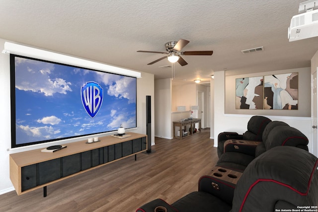 living room featuring ceiling fan, hardwood / wood-style floors, and a textured ceiling