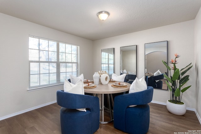 dining space featuring dark hardwood / wood-style floors and a textured ceiling