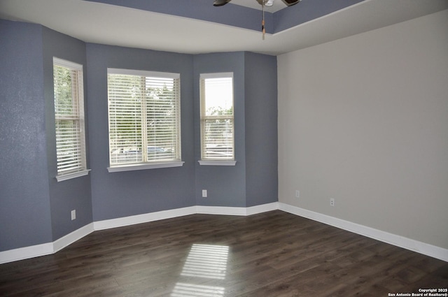 spare room featuring dark wood-type flooring and ceiling fan