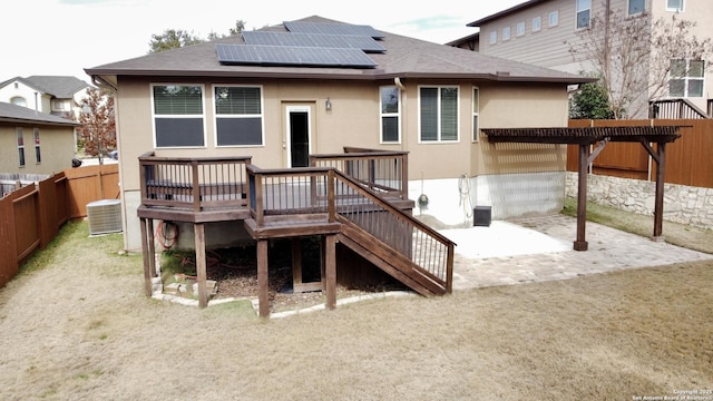 back of house featuring solar panels, a wooden deck, central AC, and a patio area