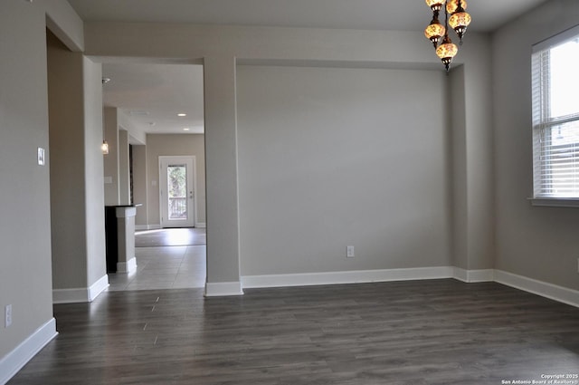 spare room featuring dark wood-type flooring and a wealth of natural light