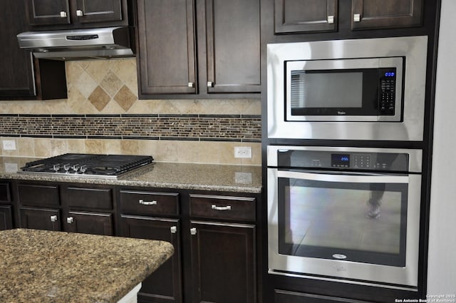 kitchen with tasteful backsplash, appliances with stainless steel finishes, and dark brown cabinetry