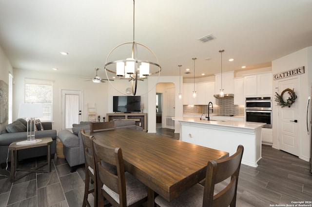 dining space with sink, a notable chandelier, and dark hardwood / wood-style floors