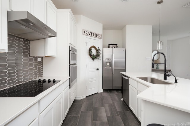 kitchen featuring stainless steel appliances, decorative light fixtures, sink, and white cabinets