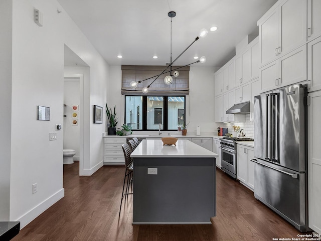 kitchen with a center island, pendant lighting, white cabinets, and premium appliances