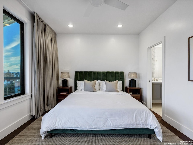 bedroom with connected bathroom, dark hardwood / wood-style floors, and ceiling fan