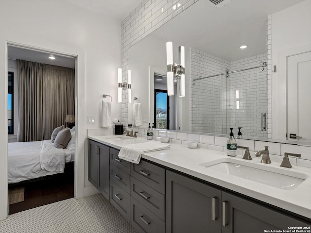 bathroom with vanity, a shower with shower door, and decorative backsplash