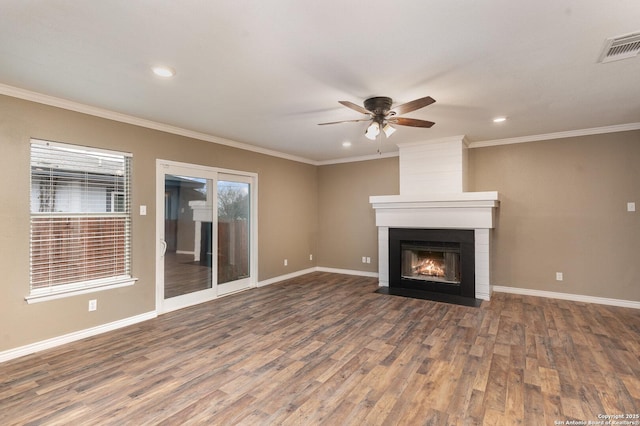 unfurnished living room featuring hardwood / wood-style flooring, ornamental molding, ceiling fan, and a fireplace