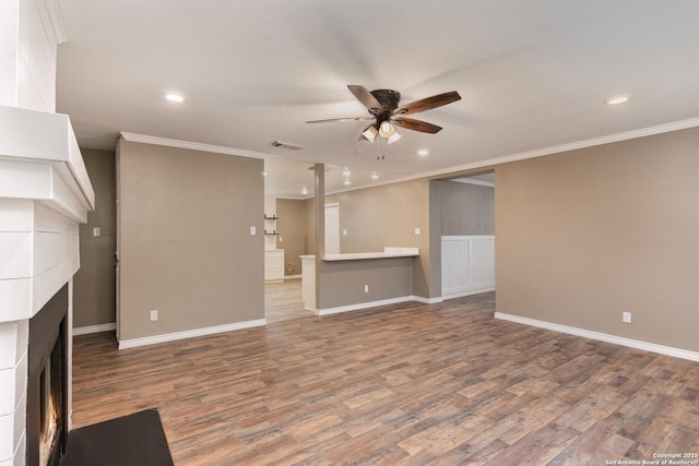 unfurnished living room with hardwood / wood-style floors, ornamental molding, a tile fireplace, and ceiling fan