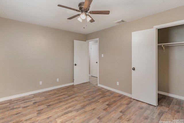 unfurnished bedroom with ceiling fan, light wood-type flooring, and a closet