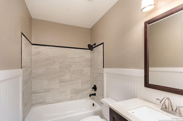 full bathroom with tiled shower / bath combo, vanity, and toilet