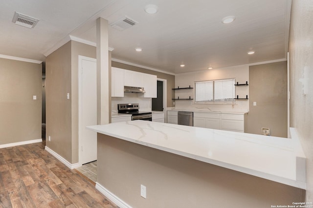 kitchen featuring kitchen peninsula, white cabinetry, light stone counters, light hardwood / wood-style floors, and stainless steel appliances