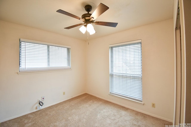 carpeted spare room featuring ceiling fan