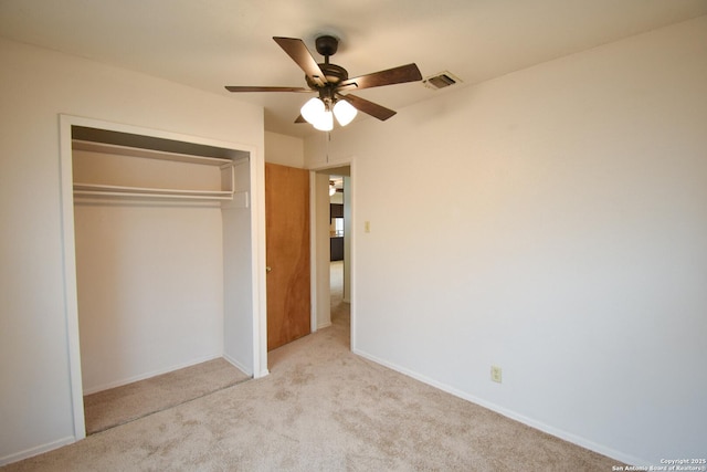 unfurnished bedroom featuring light carpet, a closet, and ceiling fan