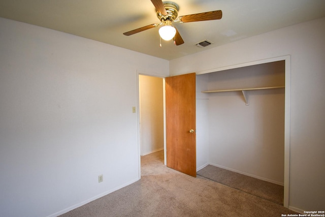 unfurnished bedroom with light colored carpet, a closet, and ceiling fan