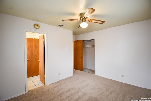 unfurnished bedroom with ensuite bath, light colored carpet, ceiling fan, and a closet