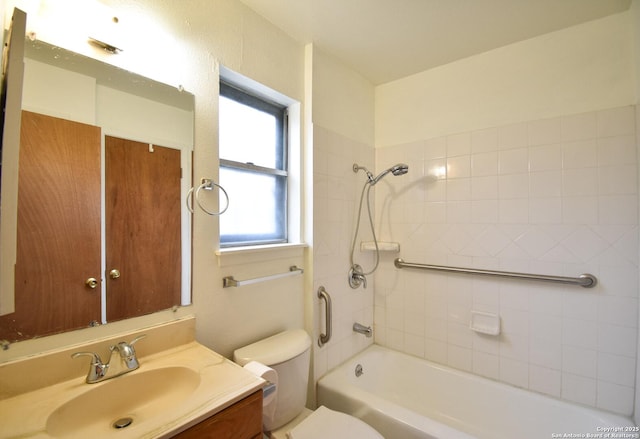 full bathroom featuring tiled shower / bath combo, vanity, and toilet