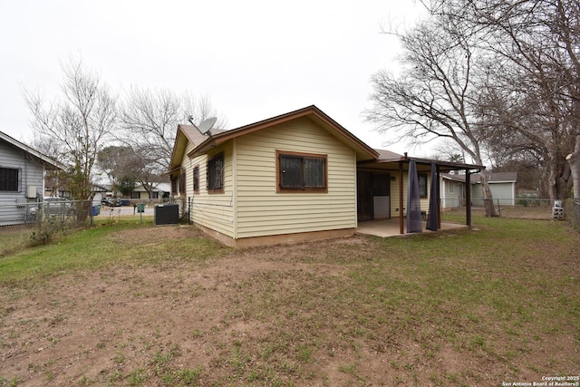 rear view of property featuring a patio, central AC unit, and a lawn