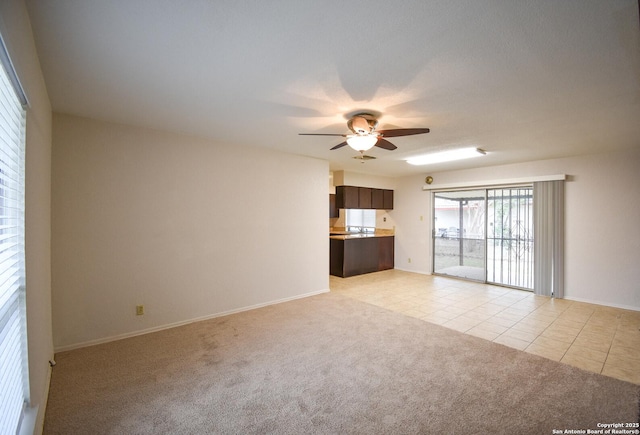 unfurnished living room featuring ceiling fan and light carpet