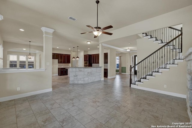 unfurnished living room with decorative columns and ceiling fan