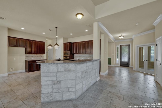 kitchen featuring french doors, crown molding, pendant lighting, light stone countertops, and decorative backsplash