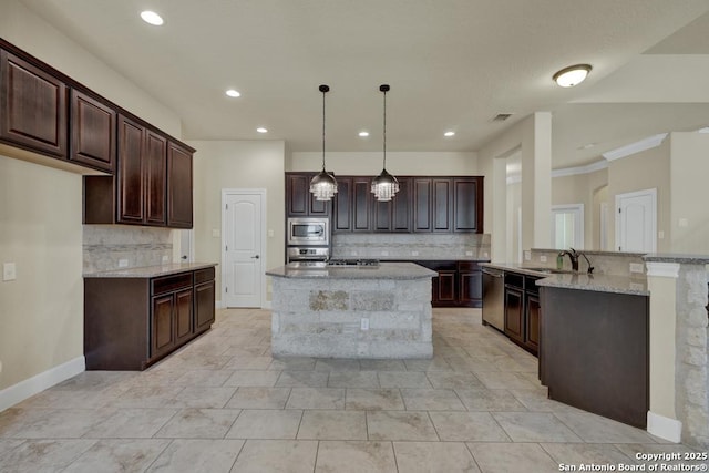 kitchen featuring pendant lighting, dark brown cabinets, stainless steel appliances, light stone counters, and a kitchen island