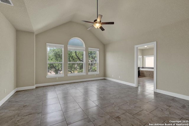 empty room with high vaulted ceiling, ceiling fan, and light tile patterned flooring