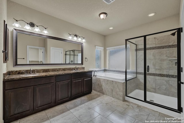 bathroom with vanity, separate shower and tub, and a textured ceiling