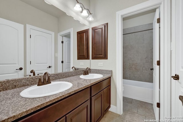 bathroom featuring tiled shower / bath, vanity, and tile patterned flooring