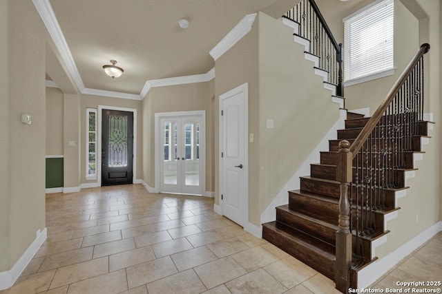 tiled entrance foyer with french doors, crown molding, and a high ceiling