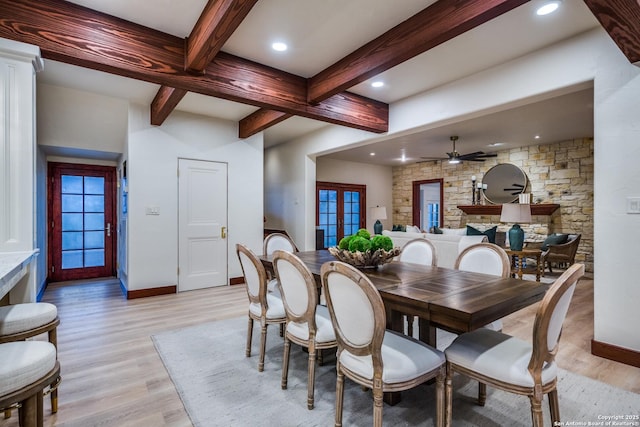 dining room with light wood-type flooring, beam ceiling, and french doors