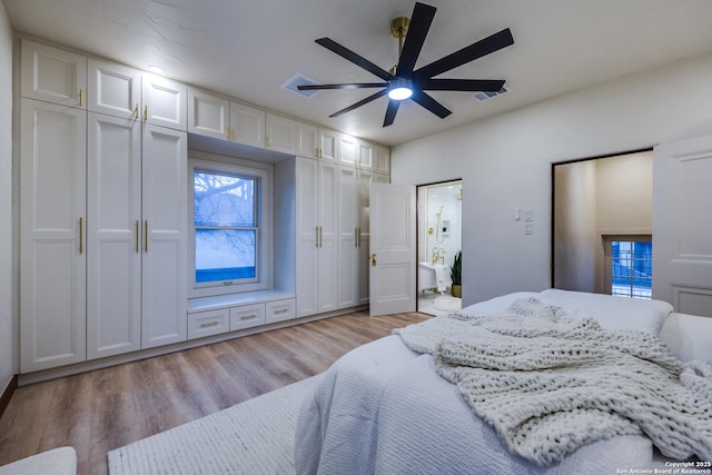 bedroom featuring ceiling fan, light hardwood / wood-style floors, and multiple windows