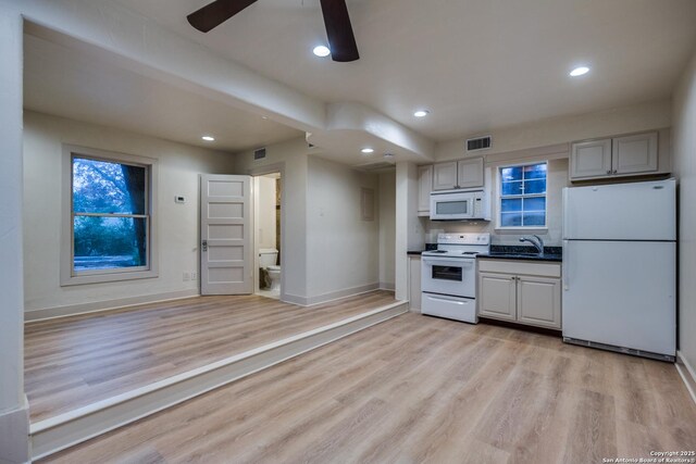 kitchen featuring ceiling fan, white appliances, sink, and light hardwood / wood-style flooring