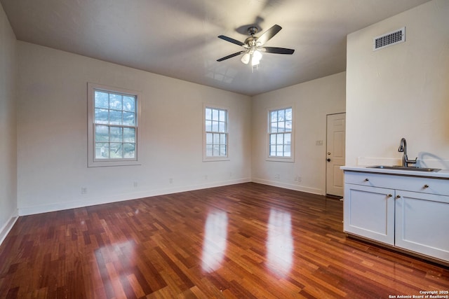 unfurnished living room with sink, dark wood-type flooring, and ceiling fan