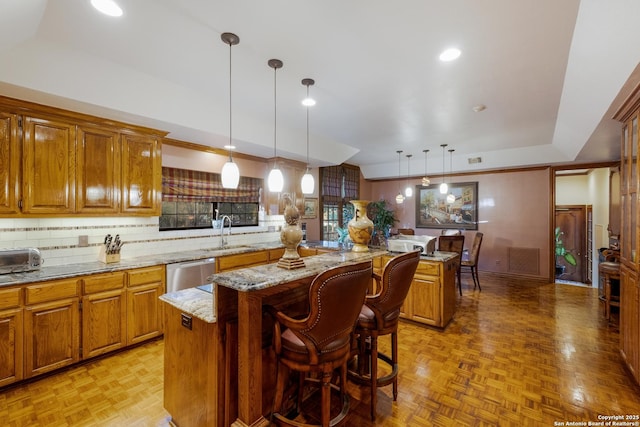 kitchen featuring a kitchen island, decorative light fixtures, dishwasher, a kitchen breakfast bar, and light parquet floors