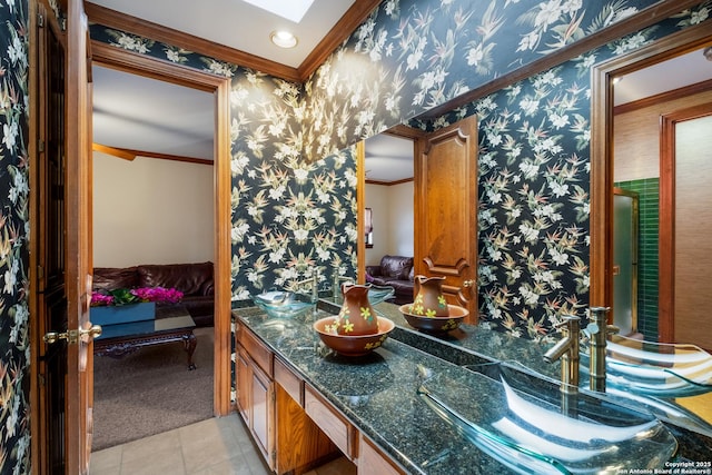 bathroom with crown molding, vanity, a skylight, and tile patterned flooring